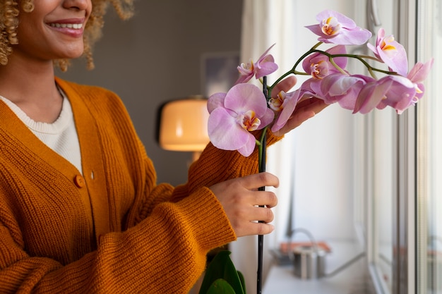 Kostenloses Foto frau schmückt ihr zuhause mit orchideen