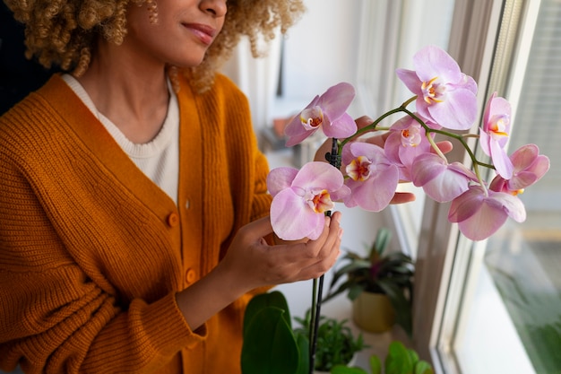 Kostenloses Foto frau schmückt ihr zuhause mit orchideen