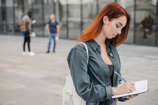 Frau schreibt im Notizbuch