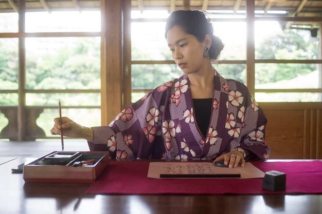 Kostenloses Foto frau schreibt mit tinte auf japanpapier