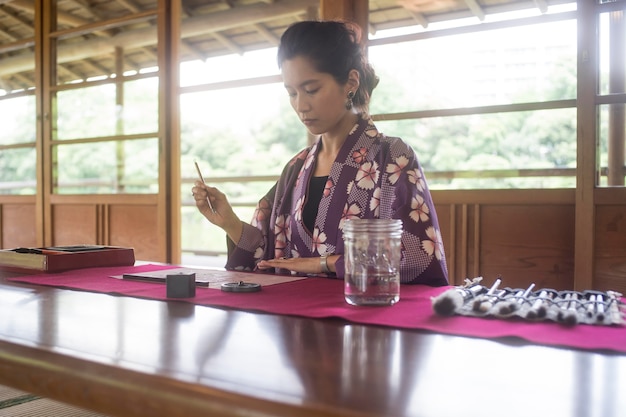 Kostenloses Foto frau schreibt mit tinte auf japanpapier