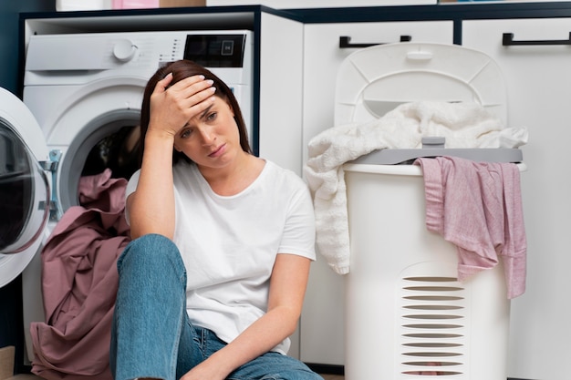 Frau sieht müde aus, nachdem sie die Wäsche gewaschen hat