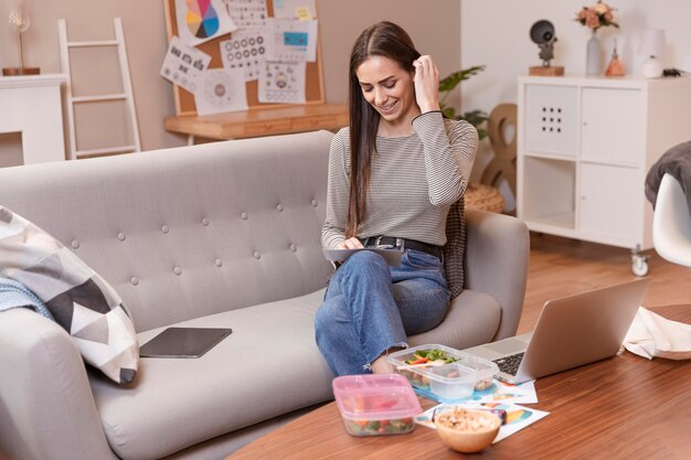 Frau sitzt auf einem Sofa und arbeitet