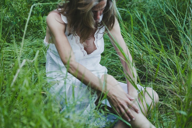 Frau sitzt auf Gras