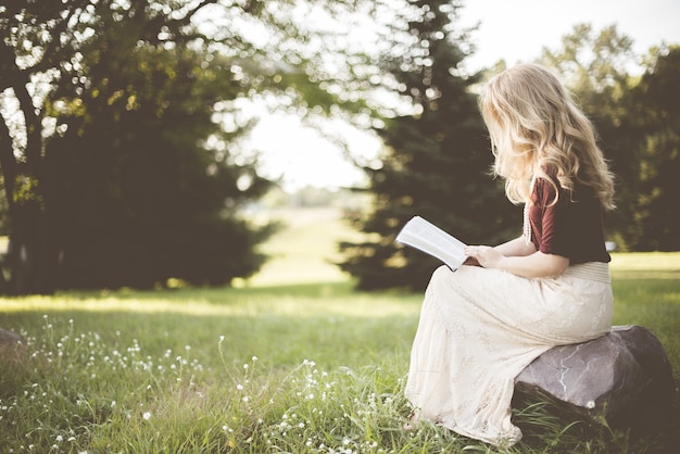 Frau sitzt beim Lesen des Buches