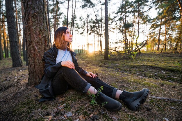 Frau sitzt in der Nähe von Baum