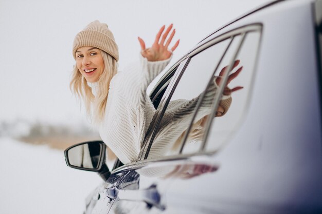 Frau sitzt in ihrem neuen Auto in einem Winterpark