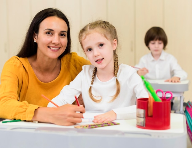 Frau sitzt neben ihrem Schüler