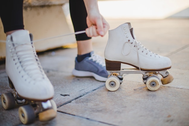 Frau sitzt Schnürung Rollschuhe