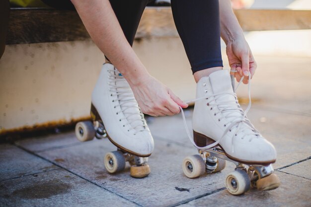 Frau sitzt Schnürung Rollschuhe