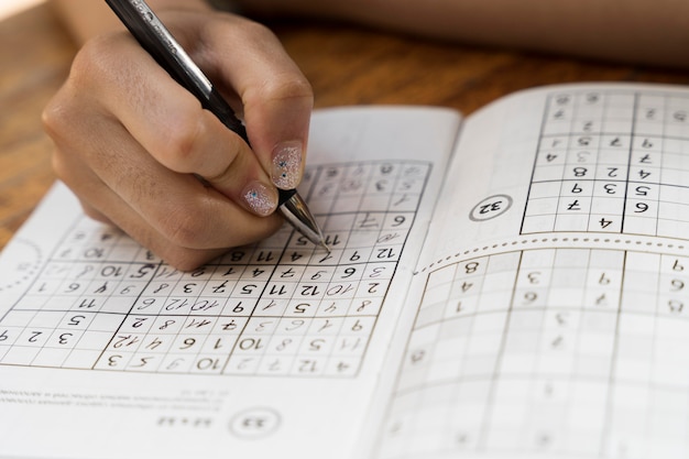 Frau spielt alleine ein Sudoku-Spiel