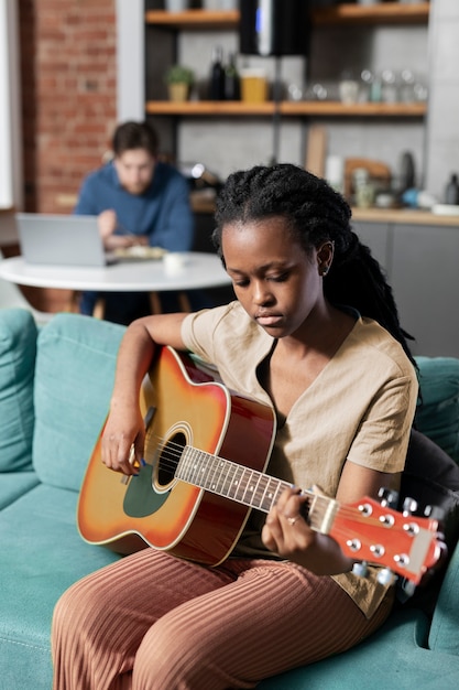 Frau spielt die Gitarre mittlerer Schuss