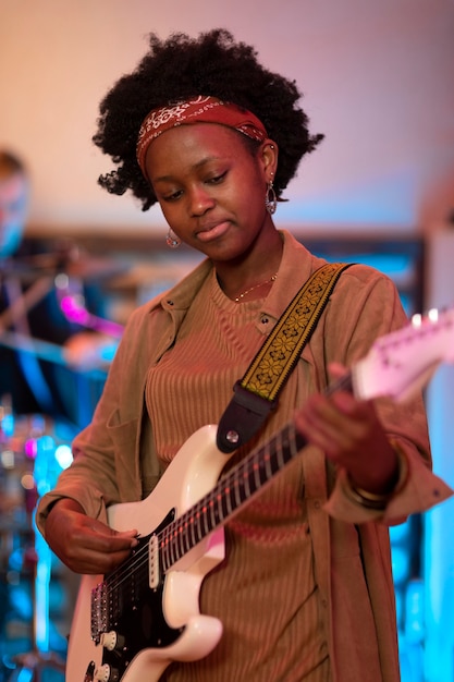 Frau spielt Gitarre bei einer lokalen Veranstaltung
