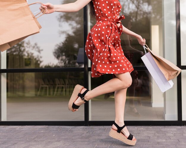 Frau springt und hält Taschen