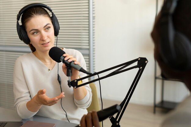 Frau stellt Fragen in einem Podcast