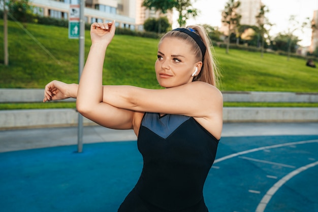 Frau streckt Muskeln im Fitnessstudio im Freien