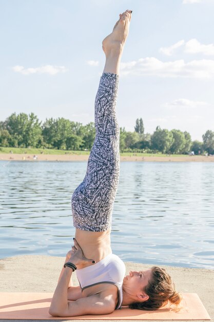 Frau streckt und konzentriert sich am Fluss