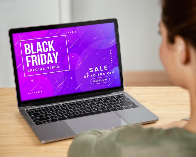 Frau sucht auf ihrem Laptop nach Black Friday-Verkäufen
