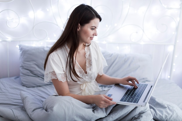 Kostenloses Foto frau surfen laptop im bett