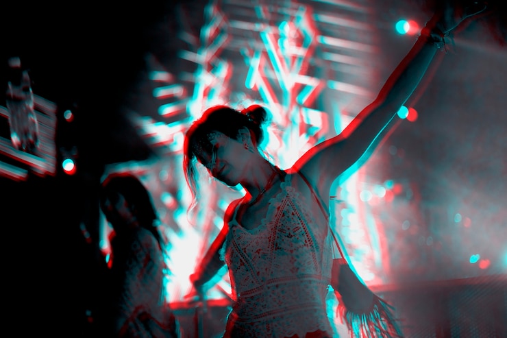 Kostenlose Foto frau tanzt auf einem musikfestival im doppelten farbbelichtungseffekt