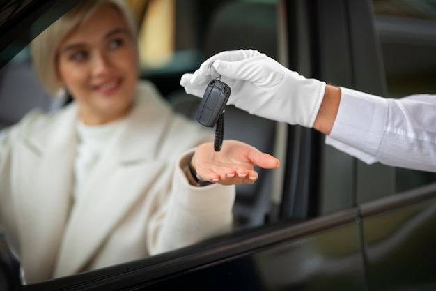 Kostenloses Foto frau tauscht autoschlüssel mit parkservice aus