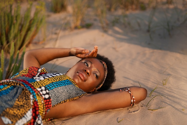 Kostenloses Foto frau trägt einheimische afrikanische kleidung in einer trockenen umgebung