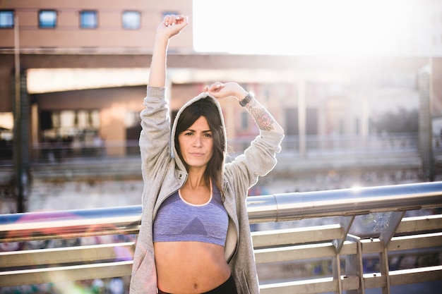 Frau trägt Sportkleidung stretching Hände hoch