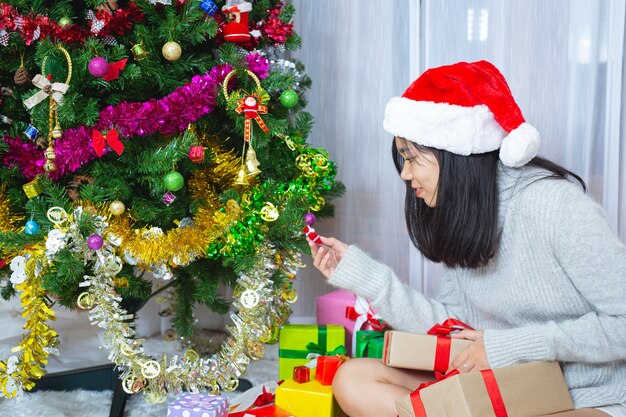 Frau trägt weihnachtsmütze glücklich mit weihnachtsgeschenk