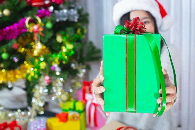 Frau trägt Weihnachtsmütze glücklich mit Weihnachtsgeschenk