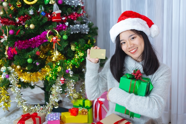 Frau trägt Weihnachtsmütze glücklich mit Weihnachtsgeschenk