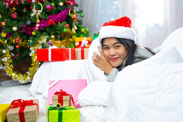 Frau trägt Weihnachtsmütze glücklich mit Weihnachtsgeschenk