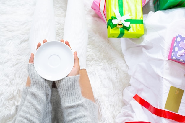 Frau trägt Weihnachtsmütze glücklich mit Weihnachtsgeschenk