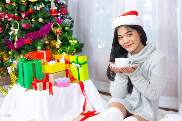 Frau trägt Weihnachtsmütze glücklich mit Weihnachtsgeschenk