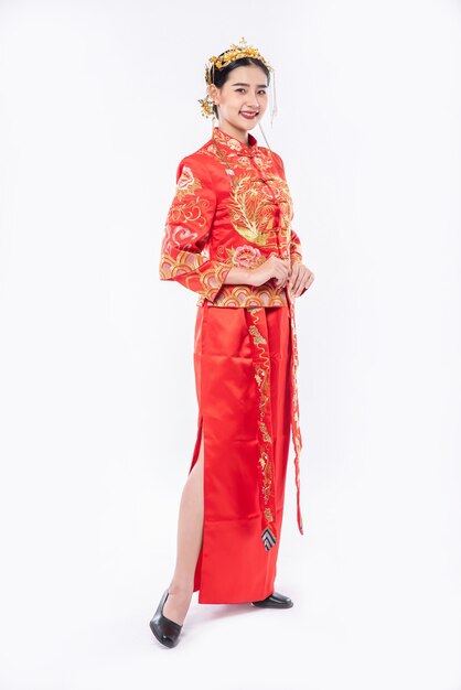 Frau tragen Cheongsam Anzuglächeln, zum des Reisendeneinkaufs im chinesischen neuen Jahr willkommen zu heißen