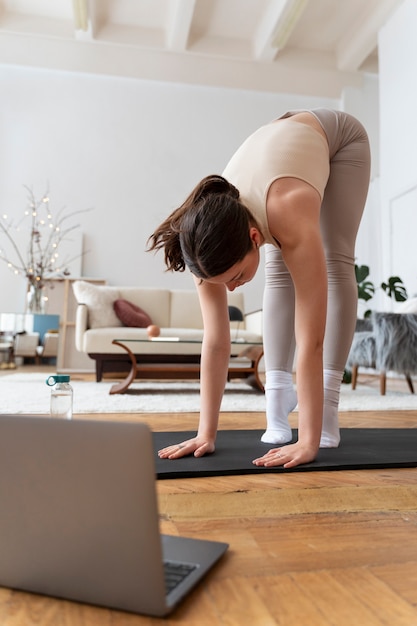 Frau trainiert nach Online-Fitnesstrainer