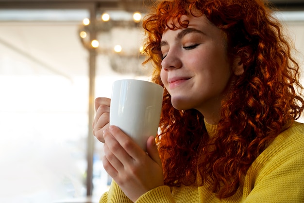 Kostenloses Foto frau trinkt heiße schokolade im café