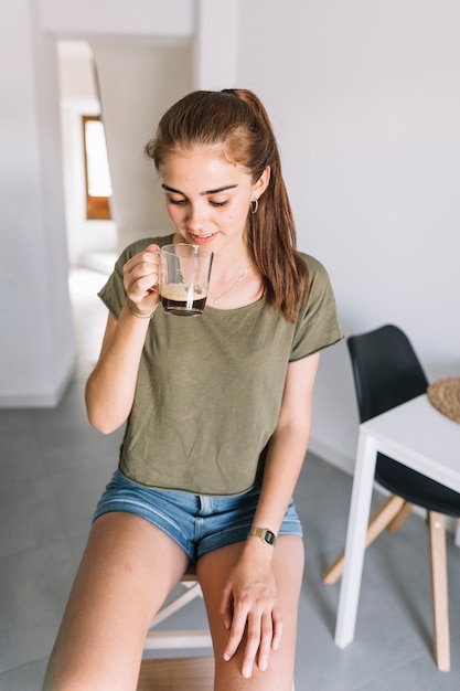 Frau trinkt Kaffee aus Glasbecher