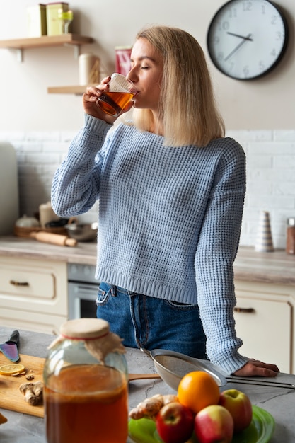 Frau trinkt Kombucha mittlerer Schuss