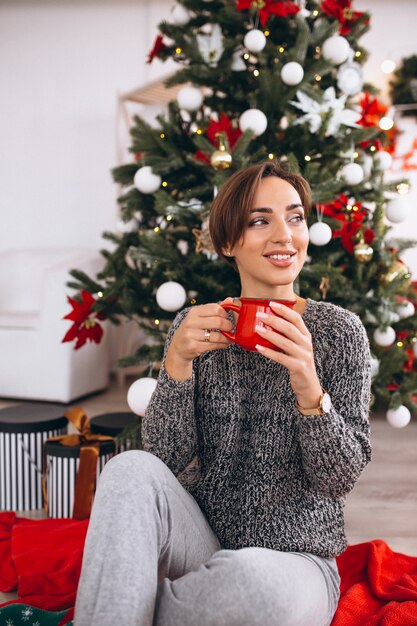 Frau trinkt Tee am Weihnachtsabend