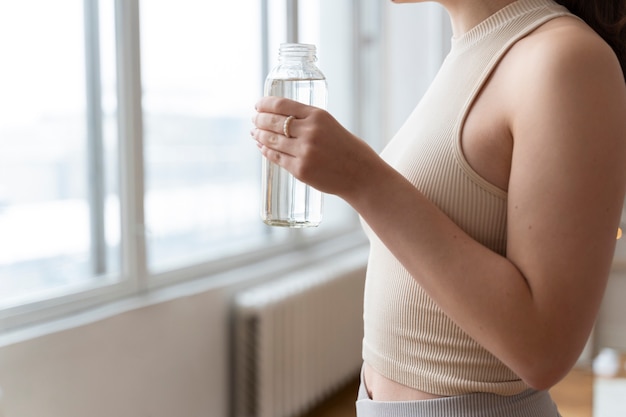 Frau trinkt Wasser nach dem Training