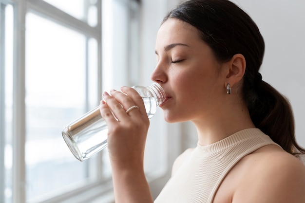 Frau trinkt Wasser nach dem Training