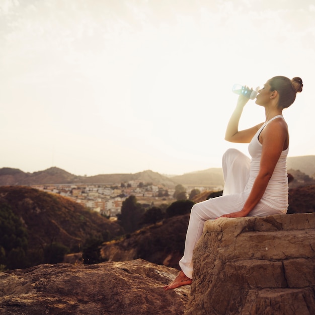 Frau trinkt Wasser nach Yoga