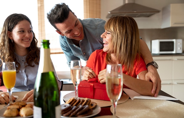 Frau überrascht mit Geschenk beim Familientreffen