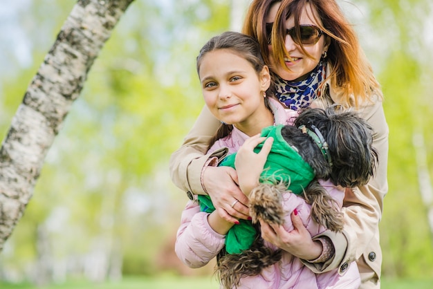 Kostenloses Foto frau umarmt ihre tochter und hund