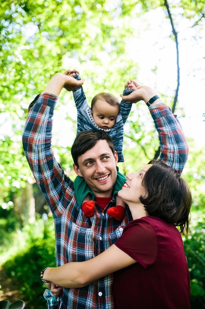 Frau umarmt Mann mit Baby draußen