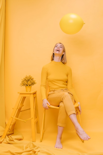 Kostenloses Foto frau und ballon in einer gelben szene