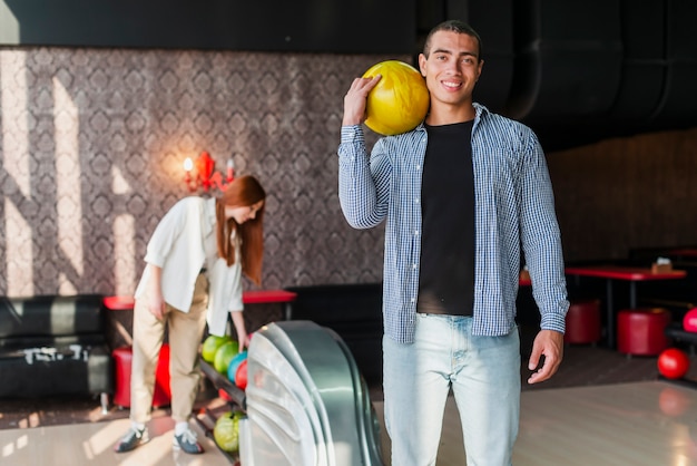 Frau und Frau mit Bowlingkugeln in einem Bowlingclub