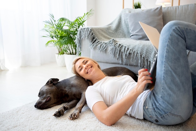 Frau und Hund mit mittlerer Aufnahme auf dem Boden