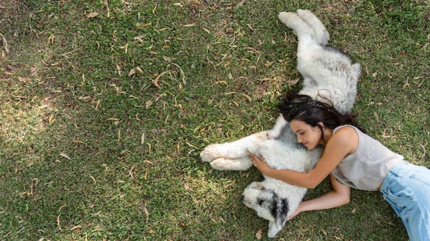 Frau und Hund sitzen auf Gras