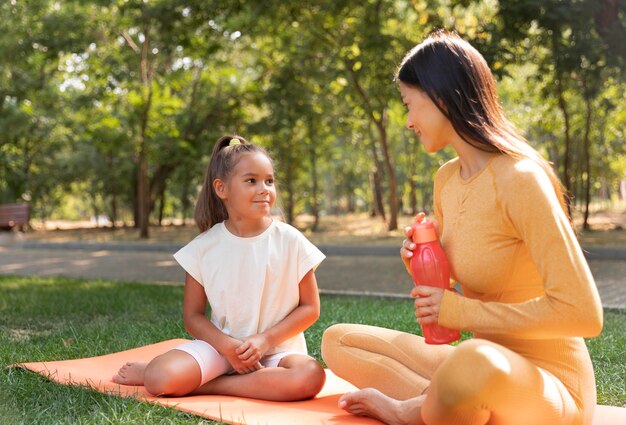 Frau und Kind auf Yogamatte voller Schuss